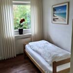 Schlafzimmer mit Bett, Fenster und Bild an der Wand.