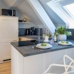 Küche mit Arbeitsplatte, Mikrowelle und Fenster
