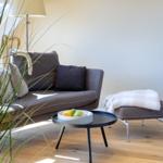 Ein Wohnbereich mit Sofa, Beistelltisch und Wanddekoration.