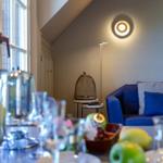 Ein Raum mit blauem Sofa, Fenster und Tisch mit Obst und Gläsern.