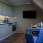 Küche mit Arbeitsplatz und TV an der Wand
