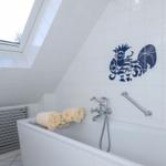 Dusche mit Dachfenster, blau-weißem Hahn-Mosaik und Handtuchhalter.