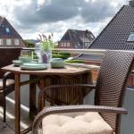 Terrasse mit Tisch, Stühlen und Blick auf Dächer.