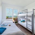 Room with bunk bed and single bed, window with sea view.