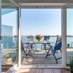 Deck with table, chairs, and flowers by waterfront
