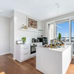 Küche mit weißer Arbeitsplatte und Blick auf Balkon.