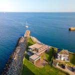 Modernes Haus mit Pool und Blick aufs Meer. Steinfassade und Gartenbereich.