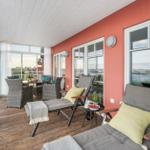 Terrasse mit Loungemöbeln und Blick auf Wasser