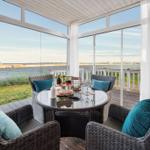 Terrasse mit Sitzgruppe und Meerblick durch Glaswände