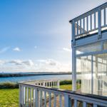 Haus mit Terrasse und Blick auf Meer und Hafen.