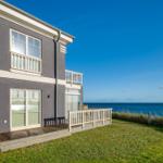 Ein zweistöckiges Haus mit Balkon und Blick auf das Meer.