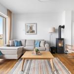 Wohnzimmer mit Sofa, Kamin und Terrassentür.