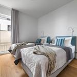 Zwei Betten mit Kopfteil, Fenster, TV und Pflanze