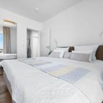 Schlafzimmer mit Doppelbett, Spiegelschrank und Blick auf Balkon.