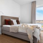 Schlafzimmer mit Bett, Fensterblick auf Hafen und TV.