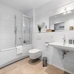 Badezimmer mit Badewanne, Dusche, Waschbecken und Spiegel