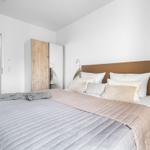 Schlafzimmer mit Bett, Nachttisch und Wandbild.
