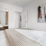 Schlafzimmer mit Bett, Wandbild und Spiegel