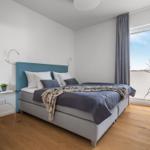Schlafzimmer mit Bett, Fenster und Pflanzen