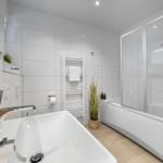 Badezimmer mit Badewanne, Dusche und Waschbecken.