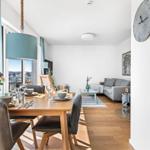 Dining area with table and chairs, living room with sofa and coffee table.