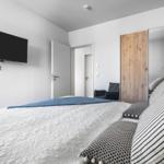 Bedroom with bed, TV, and mirror