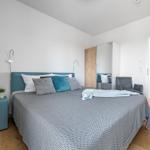 Bedroom with double bed, nightstand, mirrored wardrobe, and seating.