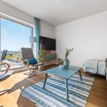 Living room with sofa, coffee table, and balcony view