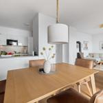 Moderne Küche mit Essbereich und Wohnzimmer im Hintergrund.