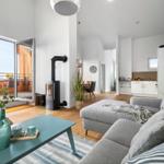 Wohnbereich mit Sofa, Kamin und Balkonansicht.