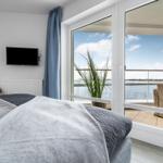 Schlafzimmer mit Blick auf die Terrasse und das Wasser.