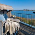 Terrasse mit Liege und Blick auf Wasser und Ferienhäuser.