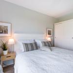 Schlafzimmer mit Bett, Nachttisch, Kleiderschrank und Stuhl.