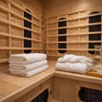 Sauna mit Holzwand, Handtuchstapeln und Wassertrinkset auf Holzbank