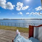 Persönliche Sicht auf einen sonnigen Tag am Wasser mit Blick auf die gegenüberliegende Uferpromenade.