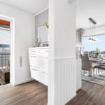 Wohnung mit Essbereich, Balkon und moderner Einrichtung. Blick auf Wasser und Himmel.