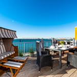 Terrasse mit Strandkorb, Esstisch und Meerblick.