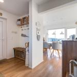 Eingangsbereich mit Holzboden und Blick in Essbereich mit Tisch und Stühlen.