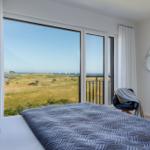 Schlafzimmer mit Blick auf Wiese und Meer