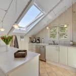Kitchen with skylight, countertop, sink, and refrigerator.