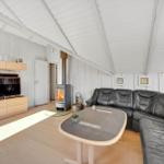 Living room with sofa, fireplace, and TV mounted on the wall.