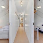 Two bedrooms with mattresses and table in hallway