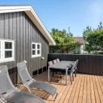 Deck with table, chairs, and loungers beside a house with dark siding.