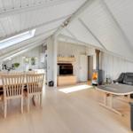 Living and dining area with wooden ceiling, fireplace, and dining table with chairs.