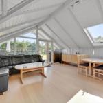Living and dining area with sofa, table, and windows to the garden.