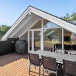 Deck with table and chairs, grill, and view into the house.