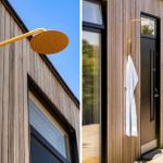 Outdoor shower with gold head mounted on wooden wall beside entrance door