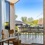 Deck with table and chairs, view of green landscape and sky