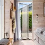 Bedroom with wooden wall, bed, and door to balcony.