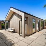 Modern wooden houses with large outdoor area and glass facades.